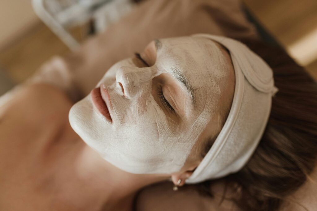 Woman enjoying a spa treatment with a relaxing facial mask indoors.